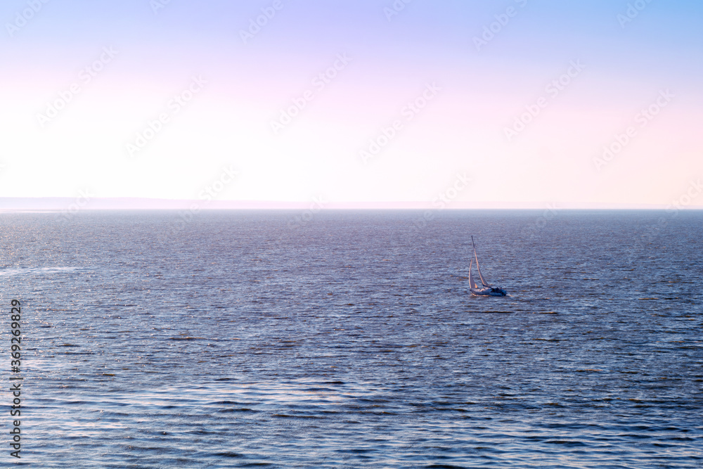 Sailboat in the sea in the evening sunlight over sky background. Luxury summer adventure or active vacation concept. Copy space