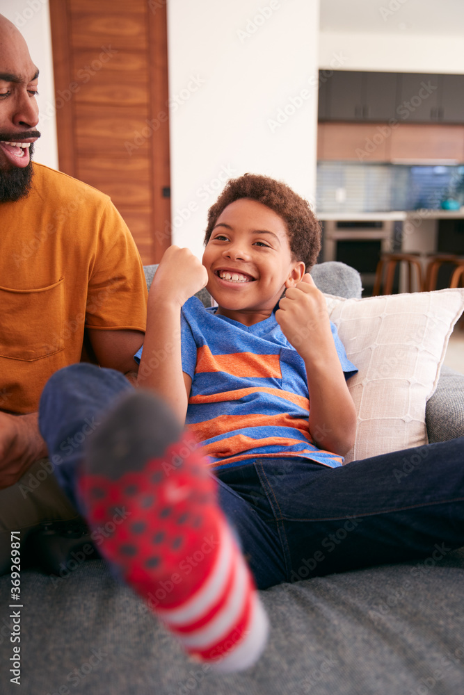 Fototapeta premium Loving African American Father And Son Sitting On Sofa At Home Together