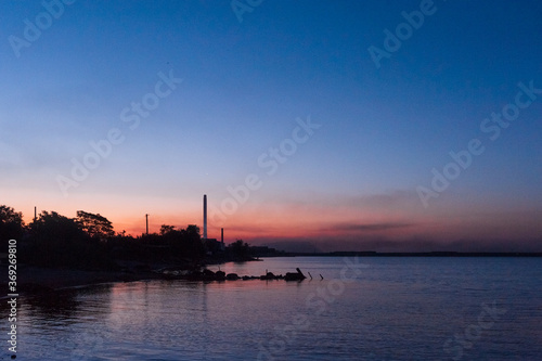 Seashore and chimney of a factory at sunrise. ​​Mariupol, Ukraine