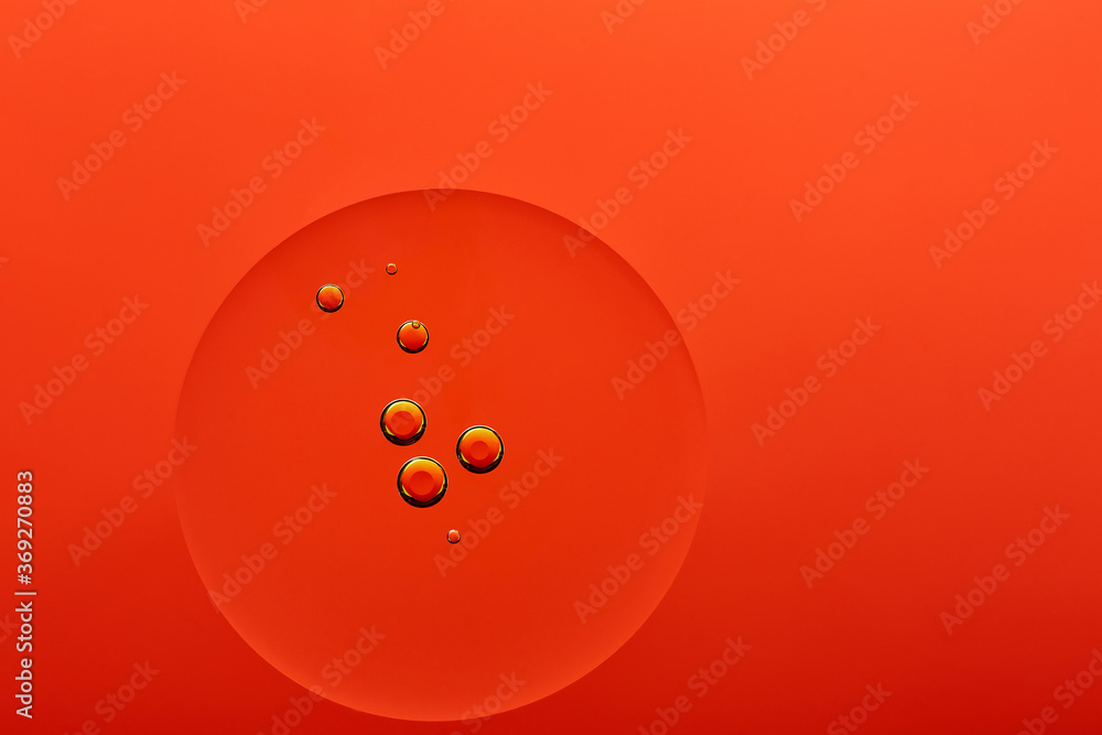 Current collection of brilliant backgrounds for your design. Close-up shot of golden oil bubbles in water circle on orange surface. Current collection of brilliant backgrounds for your design. Close-up shot of golden oil bubbles in water circle on orange surface.