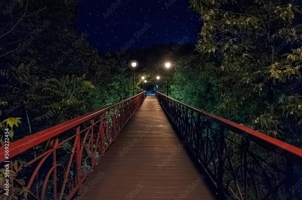 wooden Park Bridge, also known as the Bridge of Lovers in Mariinsky Park at night. Kyiv, Ukraine