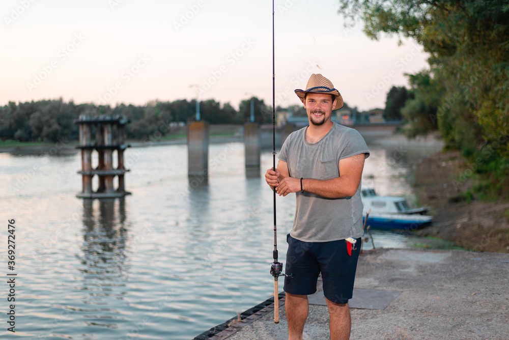 Young attractive man holding fishing rod