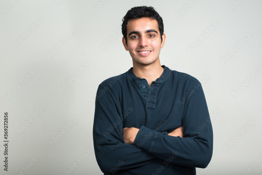 Portrait of happy young handsome Indian man smiling with arms crossed Portrait of happy young handsome Indian man smiling with arms crossed