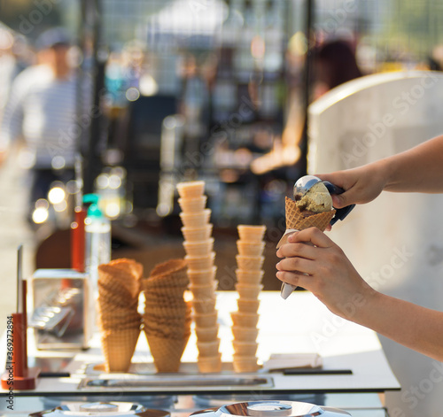 Photography Female vendor sells ice cream at Naplavka farmers street food market in Prague, Czech Republic