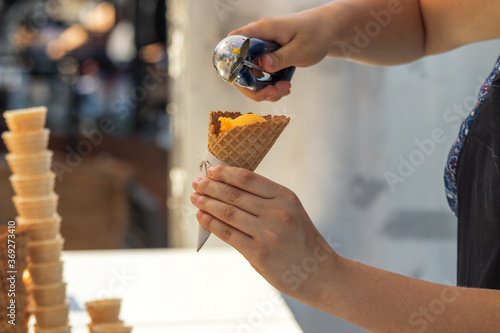 Photography Female vendor sells ice cream at Naplavka farmers street food market in Prague, Czech Republic