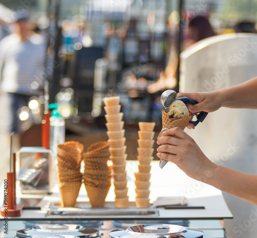 Photography Female vendor sells ice cream at Naplavka farmers street food market in Prague, Czech Republic