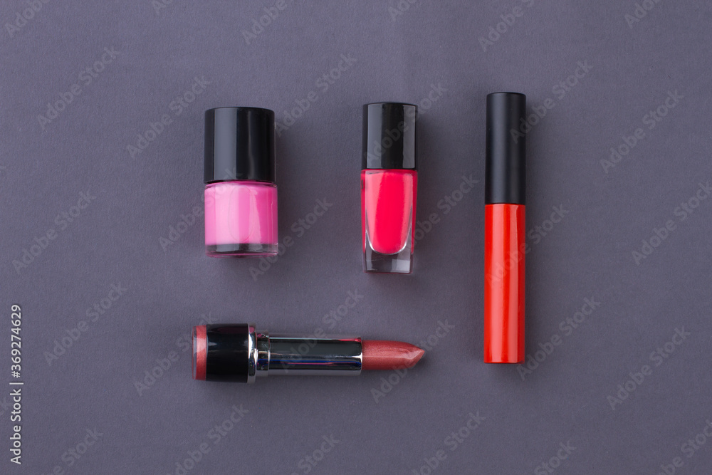 Set of layout accessories on grey background. Lipstic with mascara and lacquer. Set of layout accessories on grey background. Lipstic with mascara and lacquer.