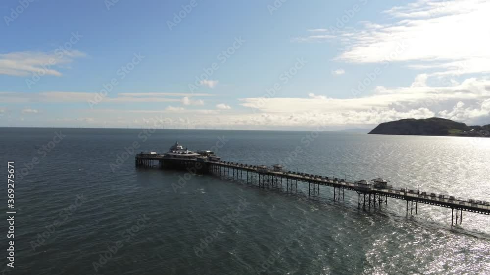 Aerial view historic Llandudno pier landmark tourist seaside promenade landmark wide orbit left
