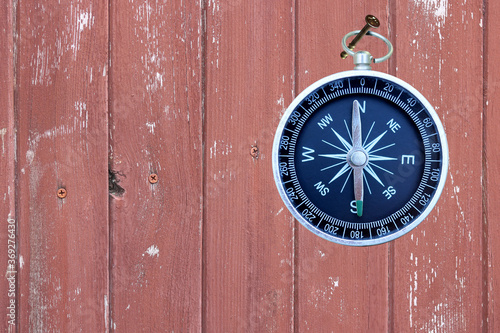 round compass on wooden background as symbol of tourism with compass, travel with compass and outdoor activities with compass