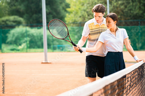 Young couple playing tennis at the court