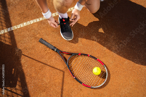 Tennis player tying his shoes © Andrii 