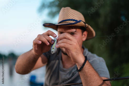 Close up photo of fisherman's hands while he's checking fishing tackle