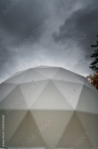 White geodesic dome tent for glamping in dark moody sky