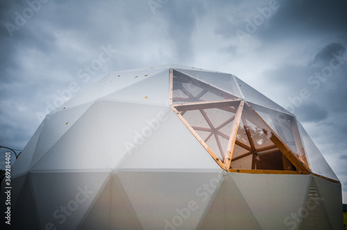 White geodesic dome tent for glamping in dark moody sky