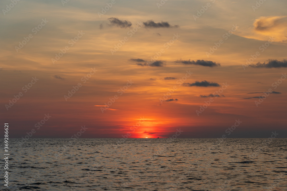 Sunset on the island of Phu Quoc, Vietnam. Travel and nature concept. Evening sky, clouds, sun and sea water Sunset on the island of Phu Quoc, Vietnam. Travel and nature concept. Evening sky, clouds, sun and sea water