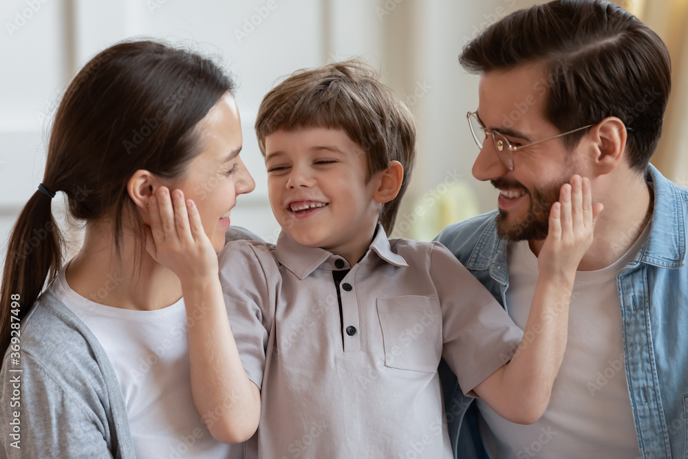 Joyful small cute child boy having fun with happy young parents, spending free time together indoors. Smiling married couple playing with little kid son, enjoying playtime, laughing joking at home. Joyful small cute child boy having fun with happy young parents, spending free time together indoors. Smiling married couple playing with little kid son, enjoying playtime, laughing joking at home.