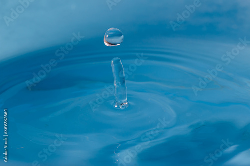 Water clear droplets higher on the surface with blue background