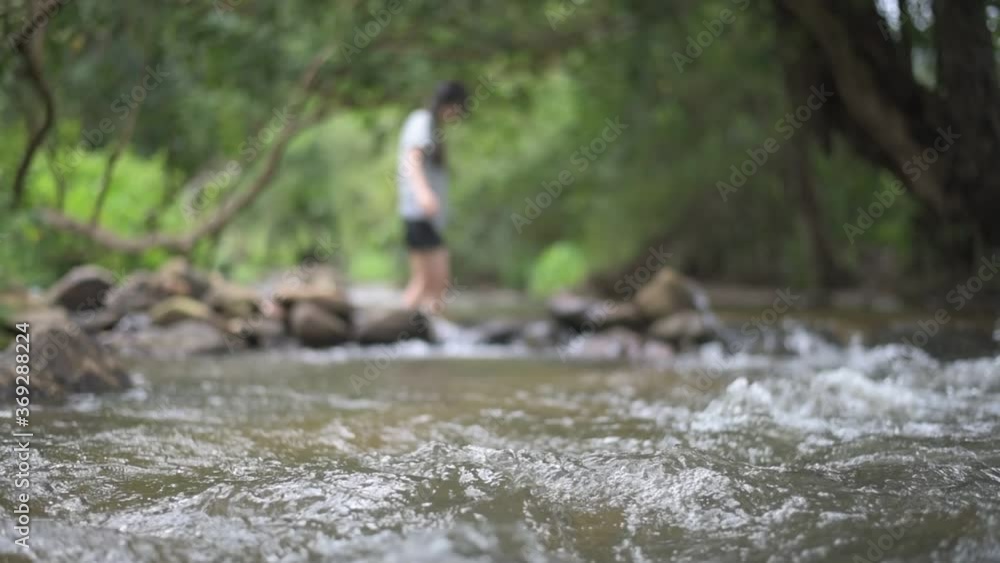 blurred of woman walking in Mountain river flowing through the green forest. , stream in the forest blurred of woman walking in Mountain river flowing through the green forest. , stream in the forest