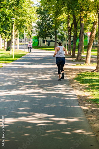 Young woman jogging along path in park © Przemyslaw Iciak