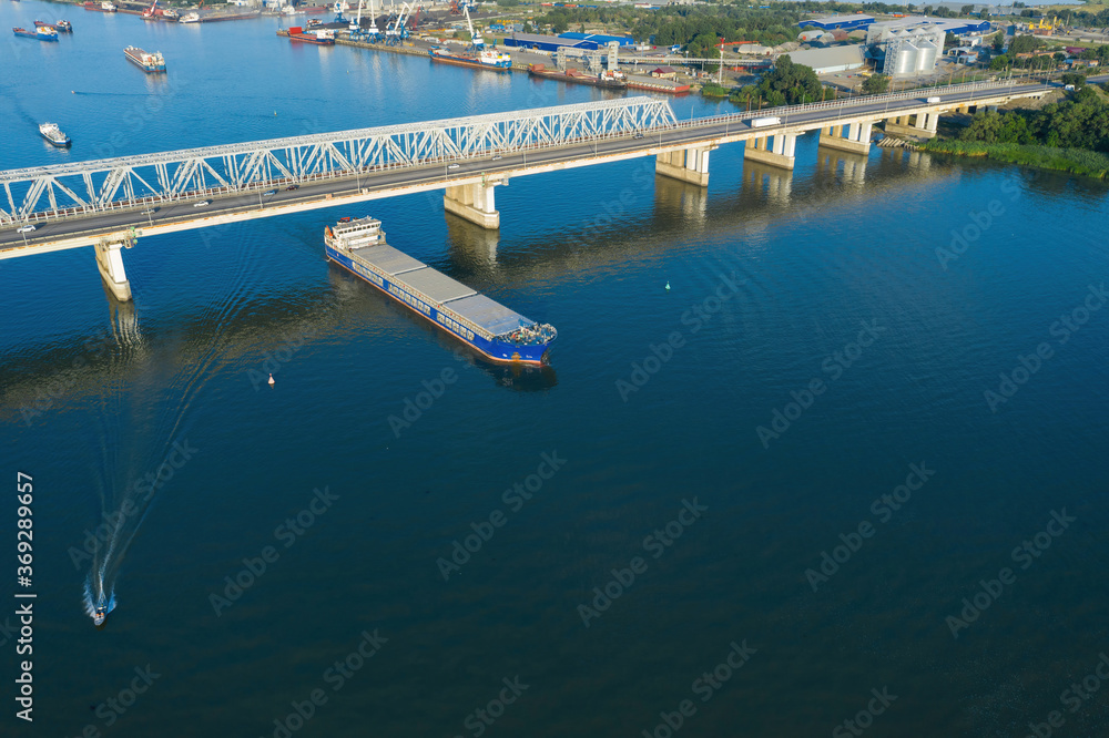 A freight ship has just passed the bridge. Aerial view. 