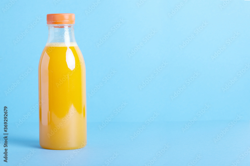 Freshly squeezed orange juice in bottle on blue background. Freshly squeezed orange juice in bottle on blue background.