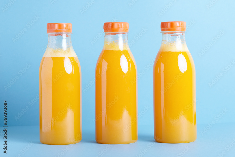 Freshly squeezed orange juice in  bottle on blue background. 