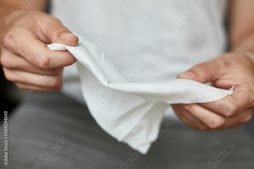 Detail Aufnahme einer Person, die sich mit einem Hygienetuch die Hände reinigt und desinfiziert