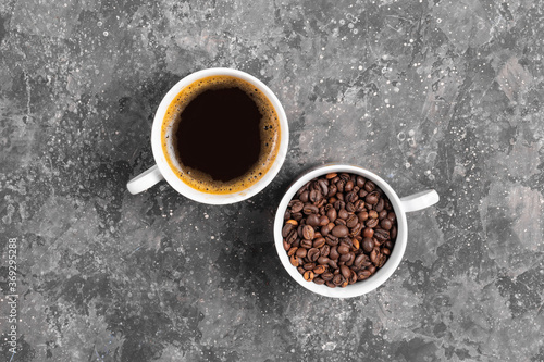 Coffee beans and espresso in white cups on gray background