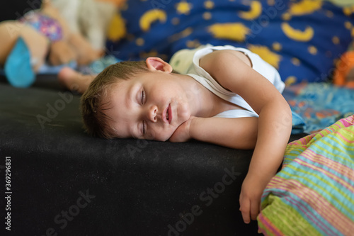 A boy fell asleep without a pillow watching TV