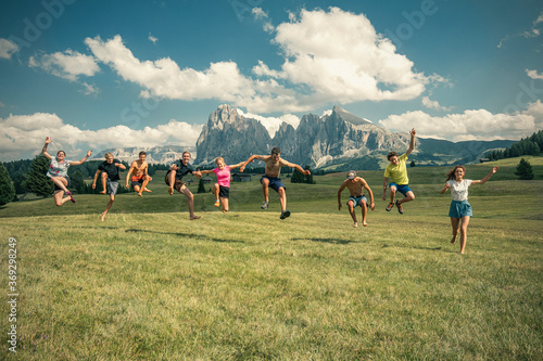 A group of people jump in the air in the middle of a mountain landscape