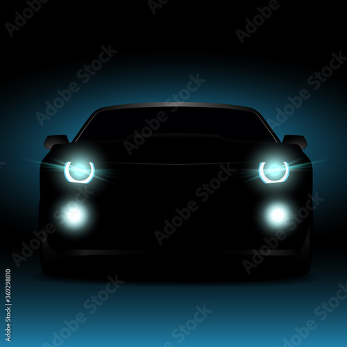 Silhouette of a car in the dark at night. Glowing car headlights and fog lights.