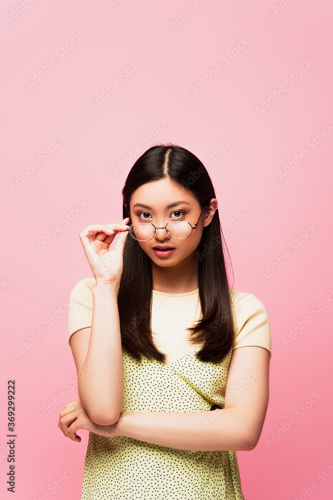 attractive asian girl touching glasses isolated on pink attractive asian girl touching glasses isolated on pink