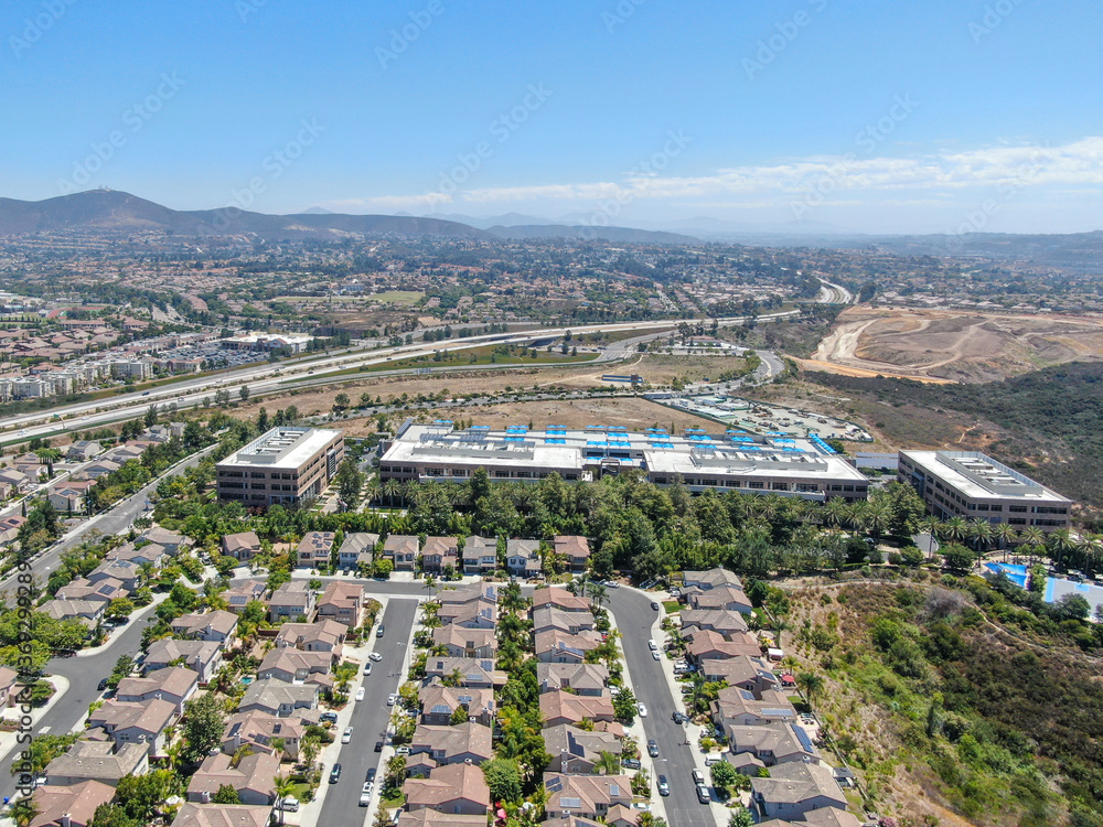 Aerial view of middle class subdivision neighborhood with residential villas and mountain on the background in San Diego County, California, USA.