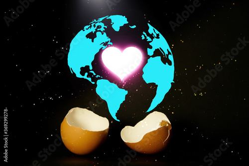 Beginning love and peaceful world ,Shining heart shape above broken egg with the world icon, Celebration of new world photo