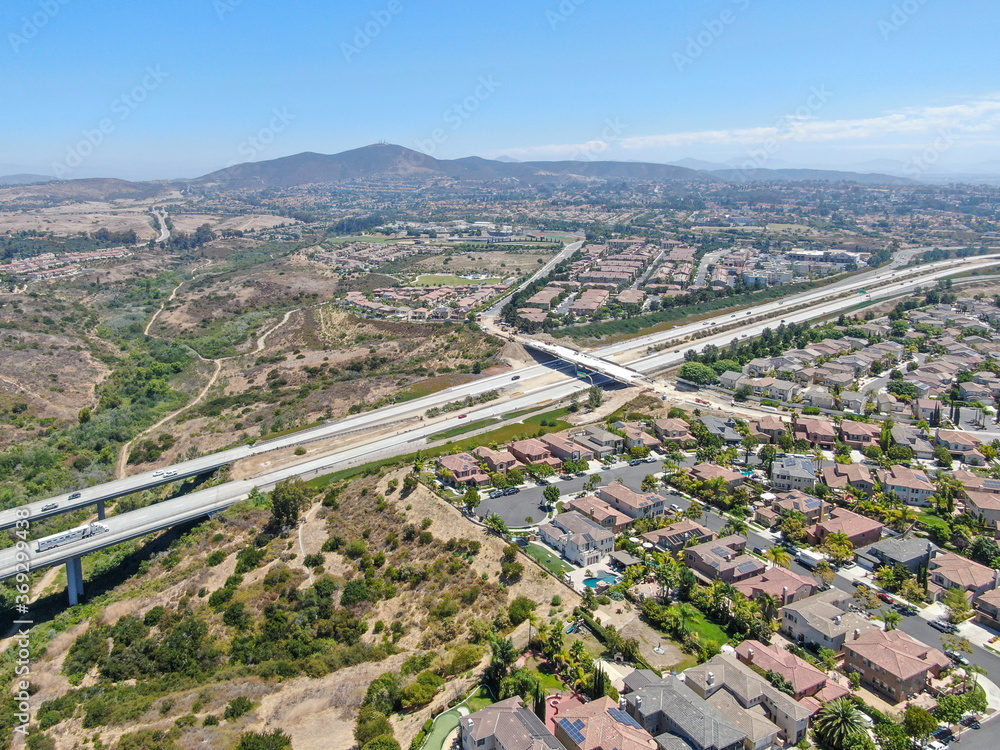 Aerial view of middle class subdivision neighborhood with residential villas and mountain on the background in San Diego County, California, USA.