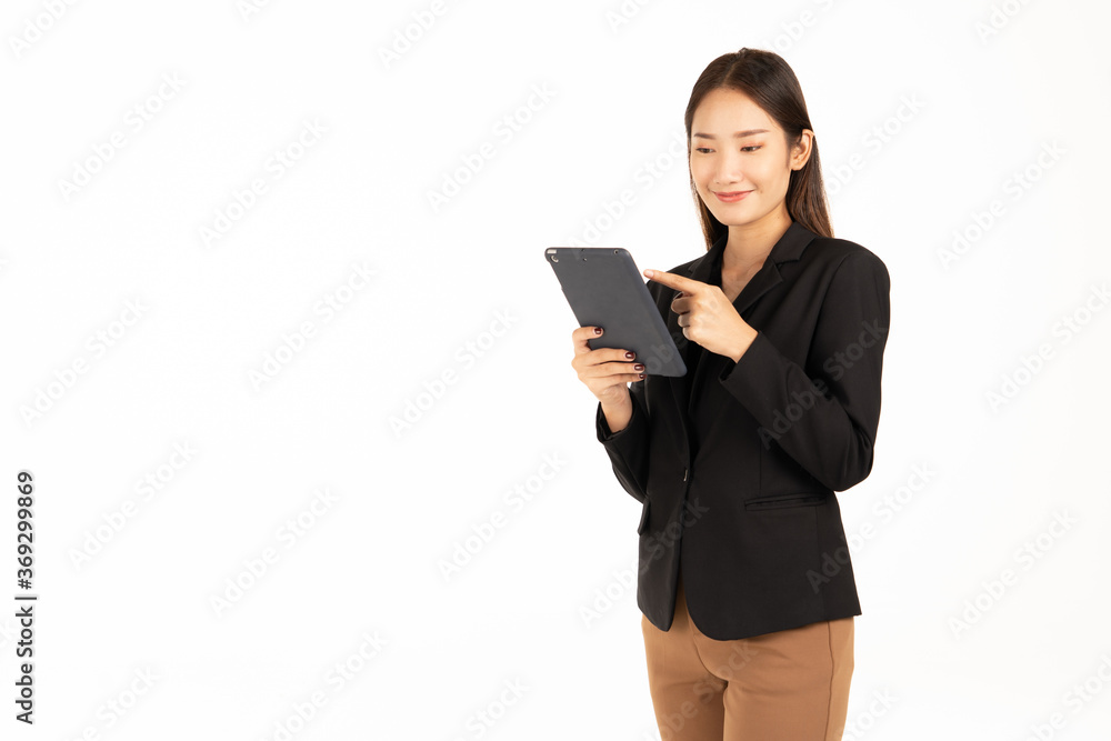 An Asian girl in a black suit stands smiling, looking at the tablet. An Asian girl in a black suit stands smiling, looking at the tablet.