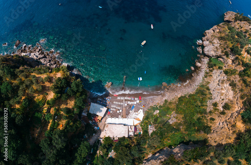 Aerial view of Laurito little cliff beach, Positano - popular tourist destination in Italy. Sunny summer day with blue sky, clear sea and green mountains of Sorrento. Travel and vacation.