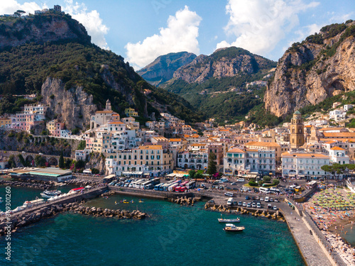 Aerial view from the sea of the Amalfi Coast with Amalfi city, Summer day. Travel and vacation to Europe mountains. Boats and ships, the most popular beach. Breakwater. Houses and hotels. Italy