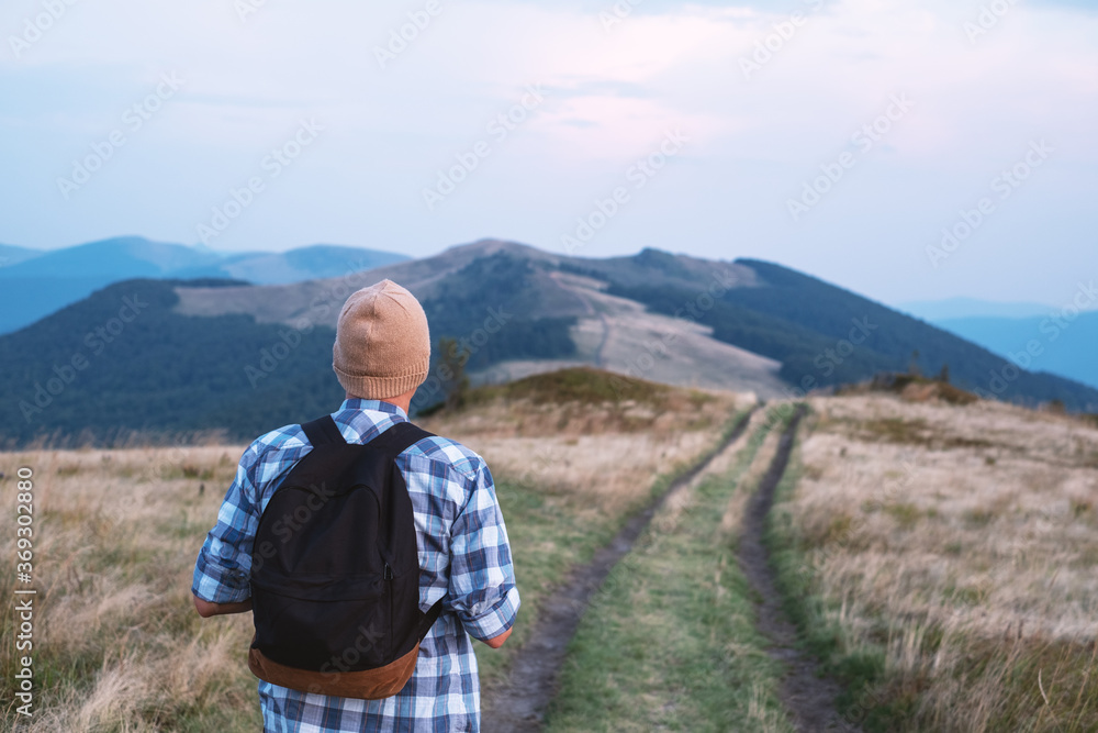 Man with backpack on mountains road. Travel concept. Landscape photography