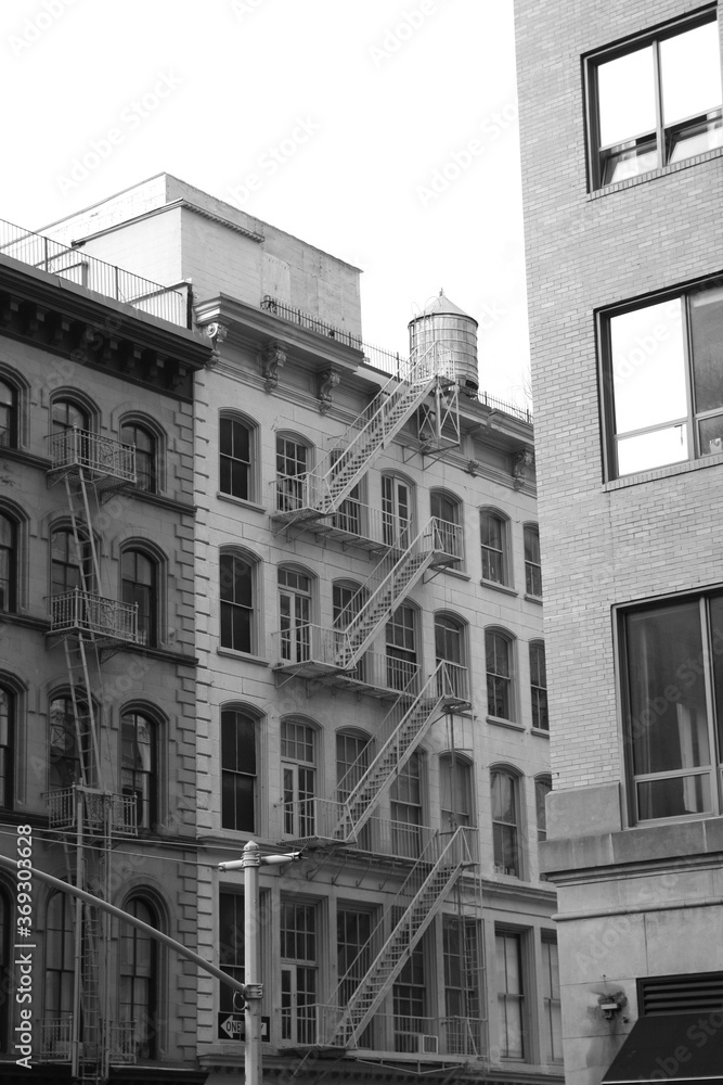 Beautiful Old Apartment Building Exterior with a Fire Escape in black and white, monochrome in Manhattan, New York City, USA, America.