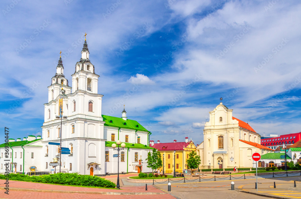 Holy Spirit Cathedral Orthodox Church Baroque style building and Church of St. Joseph in Upper Town Minsk historical city centre, blue sky white clouds in sunny summer day, Republic of Belarus