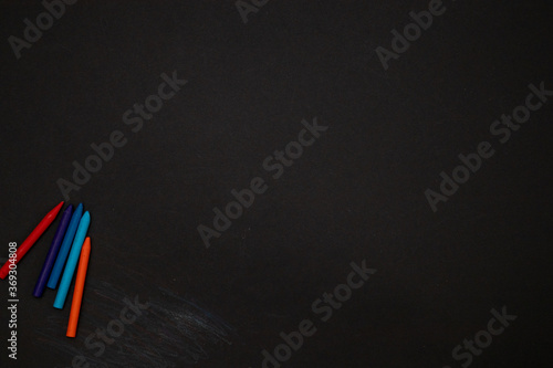 Black board background chalkboard with colored crayons for drawing. Free space. Back to school Banner blank background.