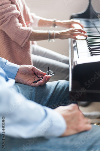 Piano teacher and music student together in front of the piano to learn acoustics new experience make late beginners music lessons classical hobby stress reduction education specialist music school