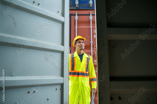 Container worker checking container box for logistic export and import in dock.