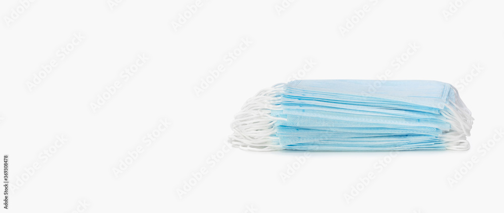 A stack of medical protective masks on a white background. Banner. Protection and prevention against coronavirus, covid-19 and other viruses.