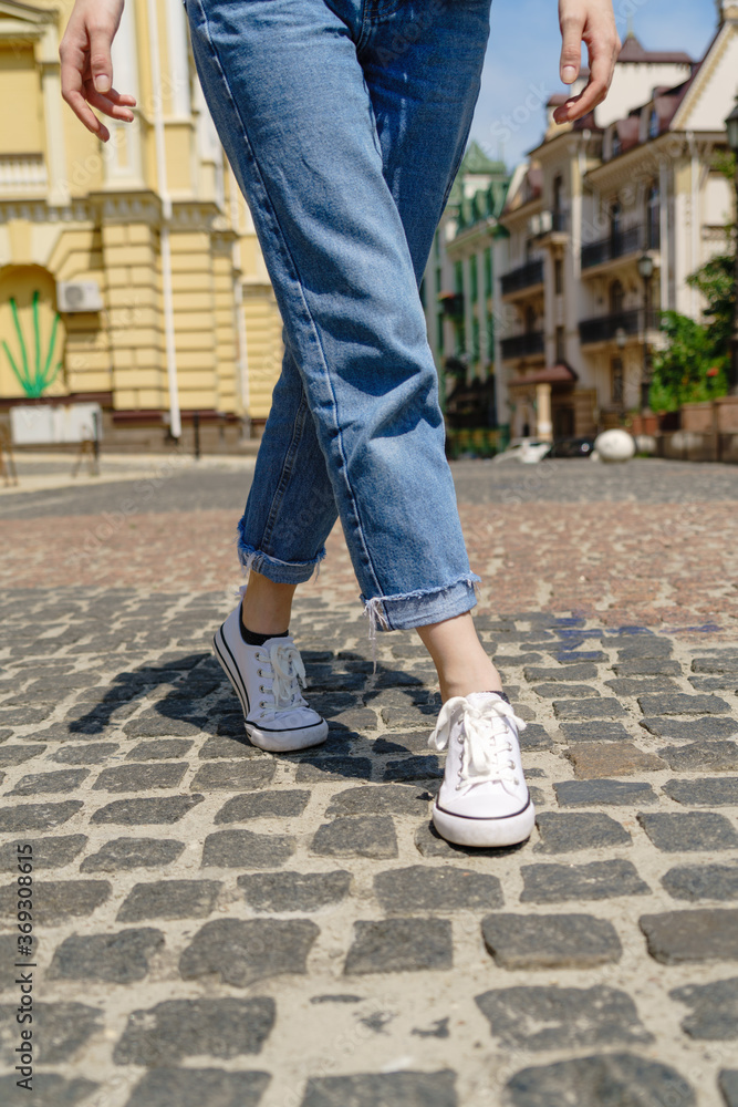 Close up of person walking on paving stone street at summer day Close up of person walking on paving stone street at summer day