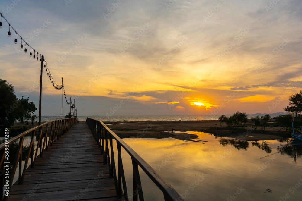 Fototapeta premium Beautiful sunset shot cloudscape over the sea with wooden bridge. (selective focus and white balance shifting applied).