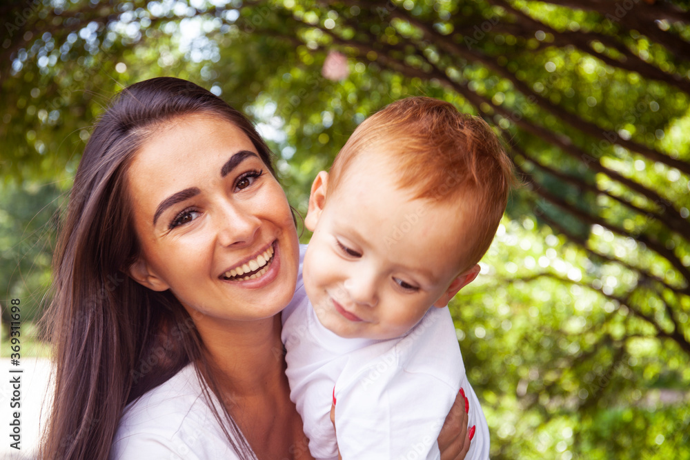 young pretty brunette mother with little cute boy walking in park happy smiling, lifestyle people concept young pretty brunette mother with little cute boy walking in park happy smiling, lifestyle people concept