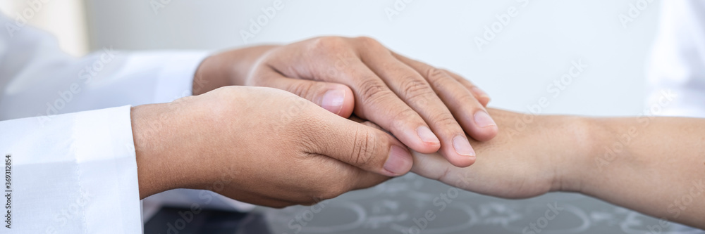 Doctor holding patient's hand to encourage talking with cheering and support Doctor holding patient's hand to encourage talking with cheering and support