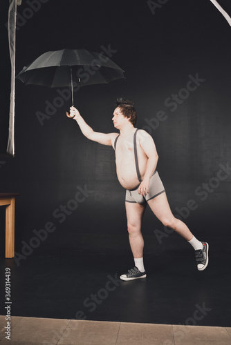 Cheerful guy walks under an umbrella
